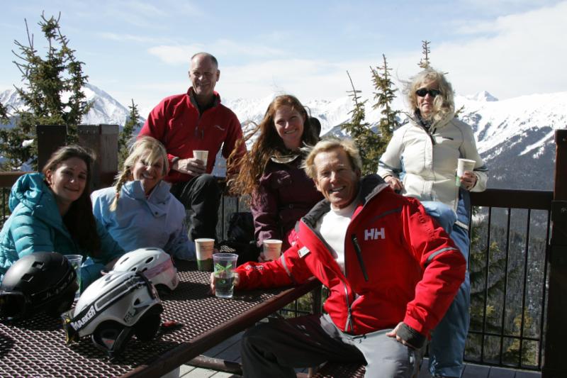 Tom Crum and a group of smiling Magic of Skiing attendees at a picinic table in winter